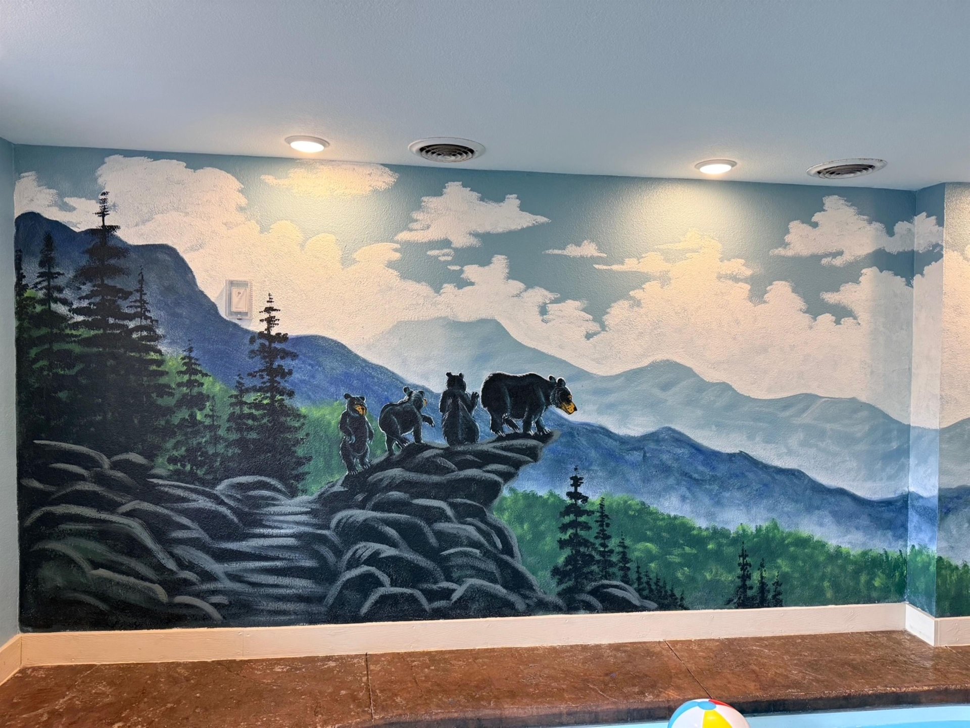 Immerse yourself in this stunning mountain wilderness mural featuring bears on rocky cliffs surrounded by pristine forest landscapes.