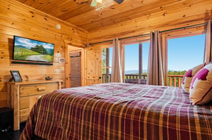 Wake up to stunning mountain vistas framed by your bedrooms expansive windows. The warm knotty pine surrounds you as natural light fills this cozy retreat, where rustic charm meets breathtaking views