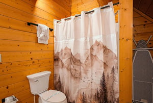 Step into this warm, woodpaneled bathroom where rustic charm meets comfort. Fresh towels and thoughtful touches make it easy to unwind after your adventures.