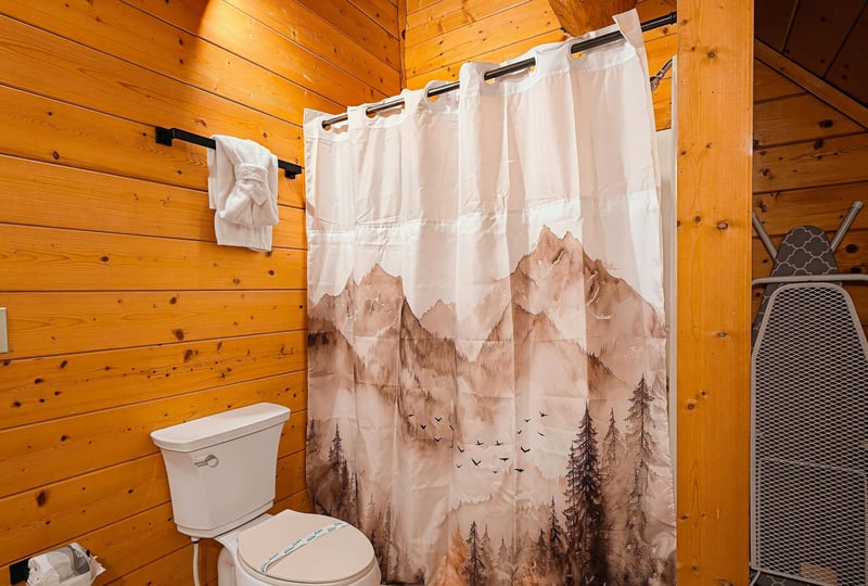 Step into this warm, woodpaneled bathroom where rustic charm meets comfort. Fresh towels and thoughtful touches make it easy to unwind after your adventures.