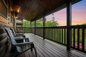 Unwind on your private deck as evening colors paint the sky above lush treetops, perfect for morning coffee or sunset relaxation.