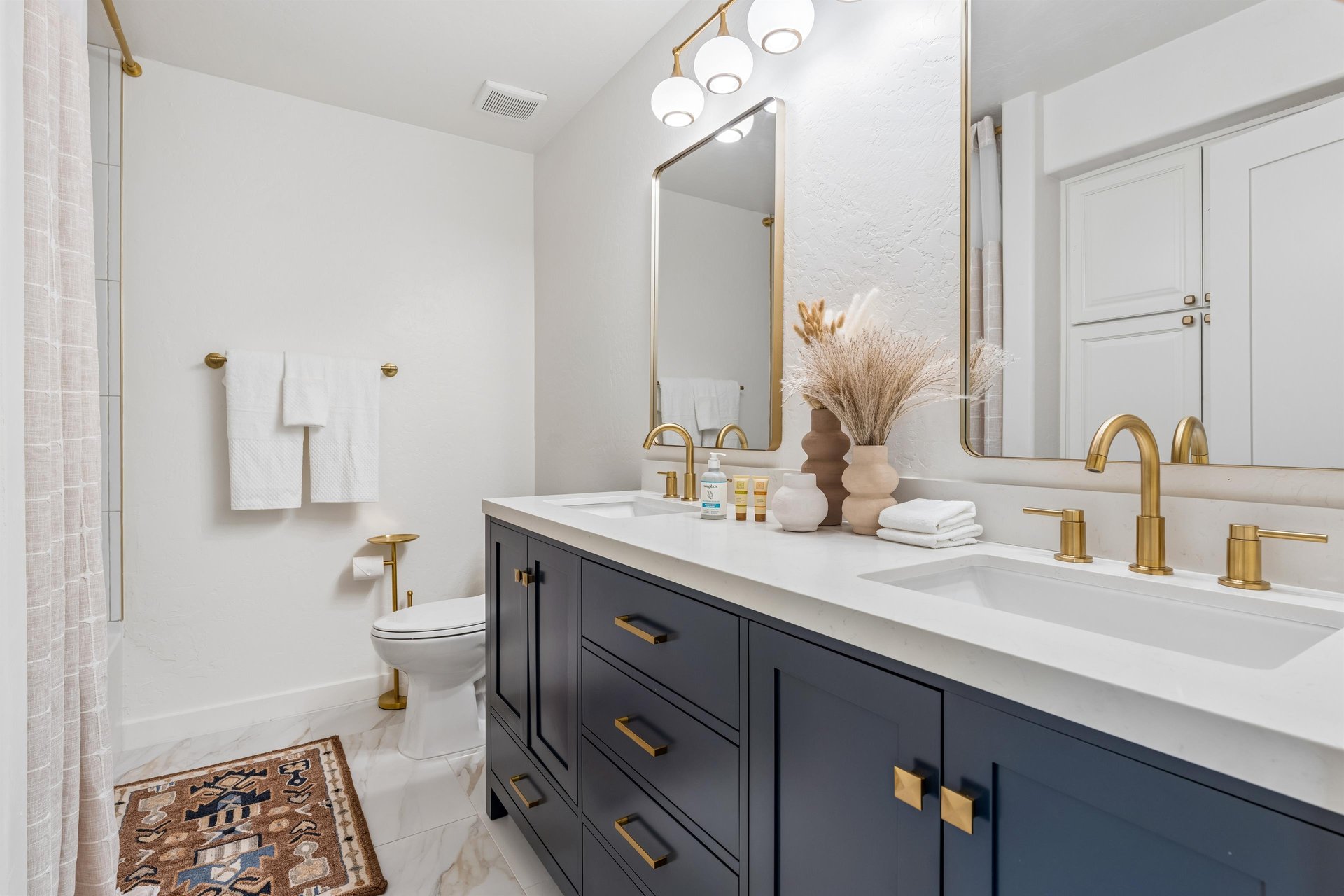 Dual vanity sink, showertub combination, and modern fixtures.