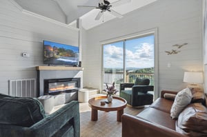 2 chairs, couch, TV and fireplace with natural lighting