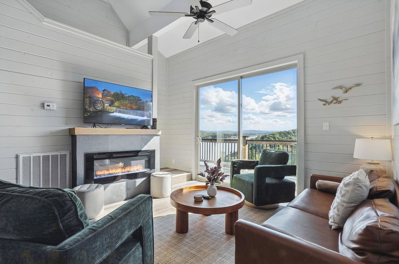 2 chairs, couch, TV and fireplace with natural lighting