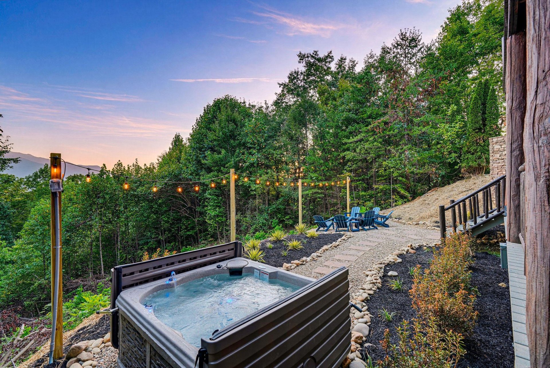 Golden hour casts a warm glow over this hillside retreat, where string lights and mountain views set the stage for peaceful evenings under open skies.