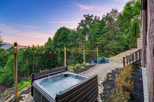 Golden hour casts a warm glow over this hillside retreat, where string lights and mountain views set the stage for peaceful evenings under open skies.