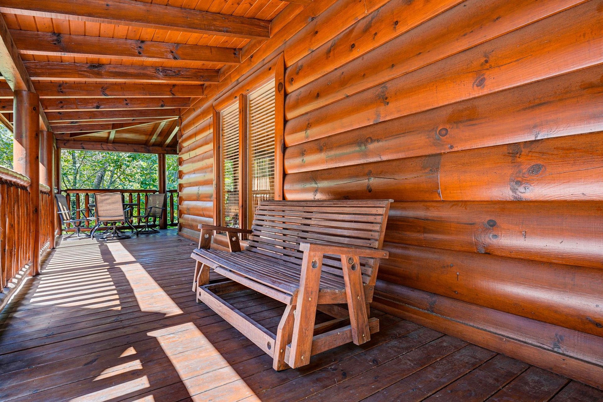 Settle into this rustic porch bench and soak in the peaceful forest views—your private retreat where morning coffee tastes better and worries drift away.