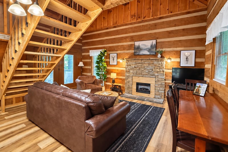 Settle into plush leather seating by your own stone fireplace, surrounded by warm wood beams and natural light—perfect for cozy evenings in the mountains.