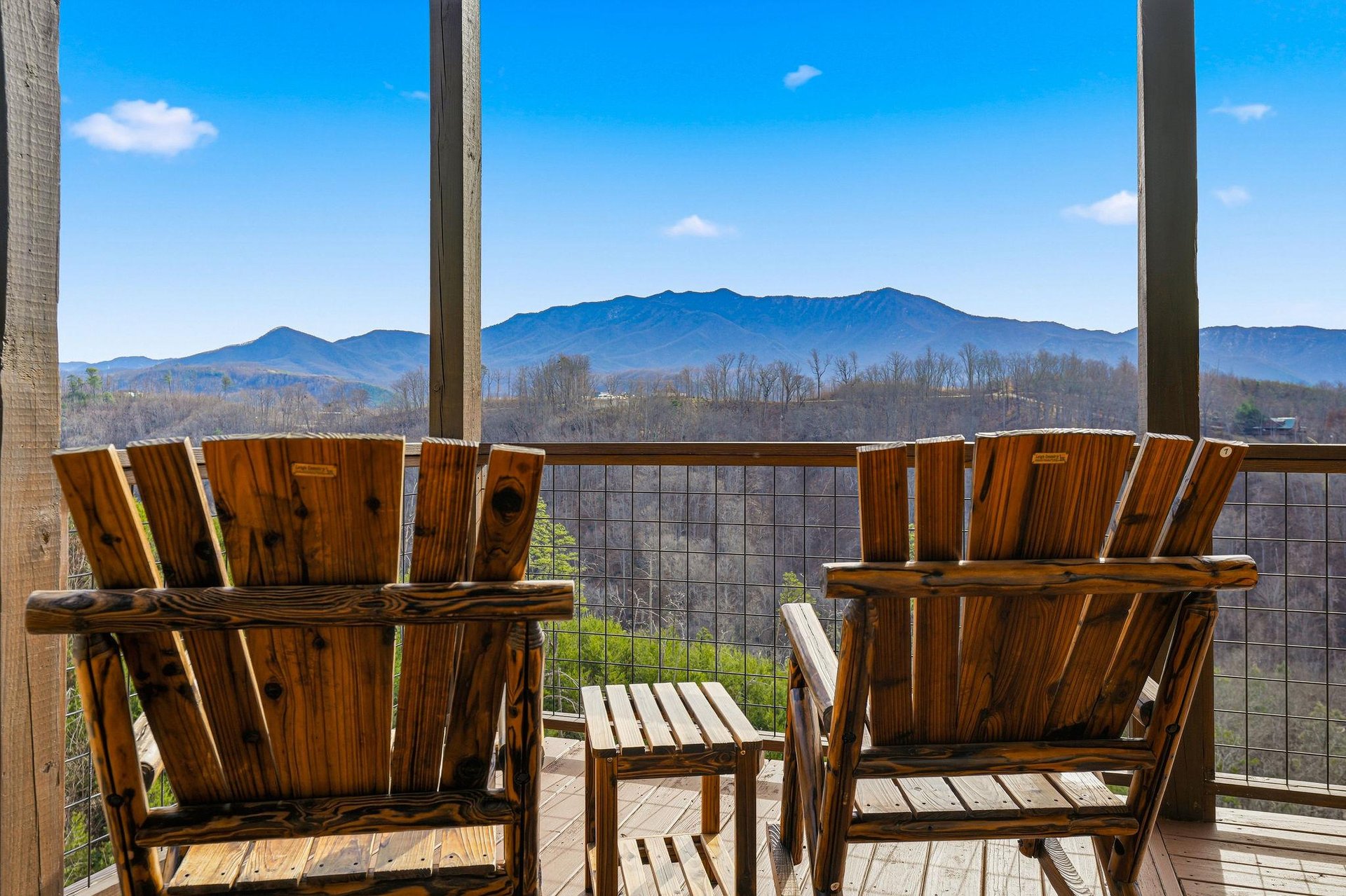 Stunning mountain views frame this peaceful balcony where you can unwind in comfortable wooden chairs and soak in the serene landscape.