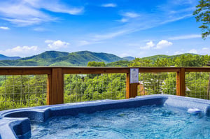 Soak away your cares in the hot tub while drinking in panoramic mountain views beneath an open sky.