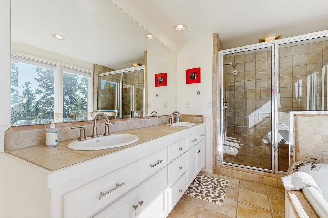 Ensuite bathroom equipped with a standalone jet tub, stand alone shower, dual vanity sink, and plenty of natural lighting.