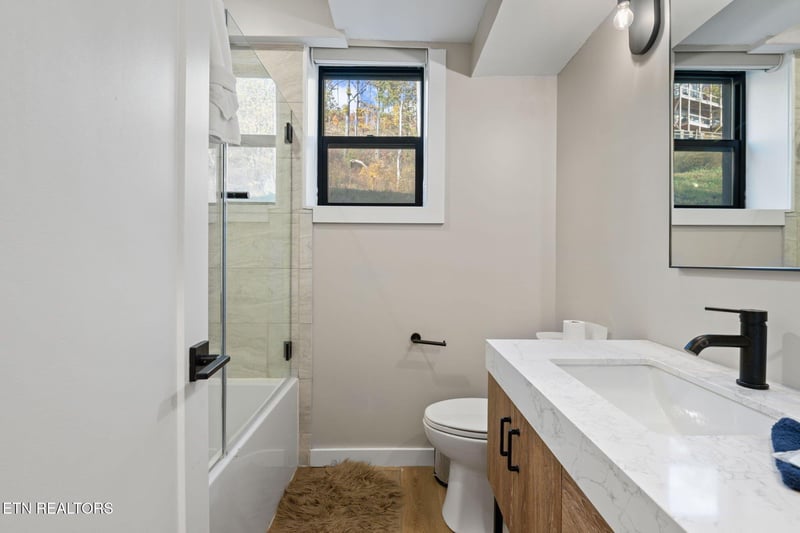 Step into your modern bathroom with a bright, airy feel—natural light through the window, a marbletopped vanity, and a refreshing walkin shower await.