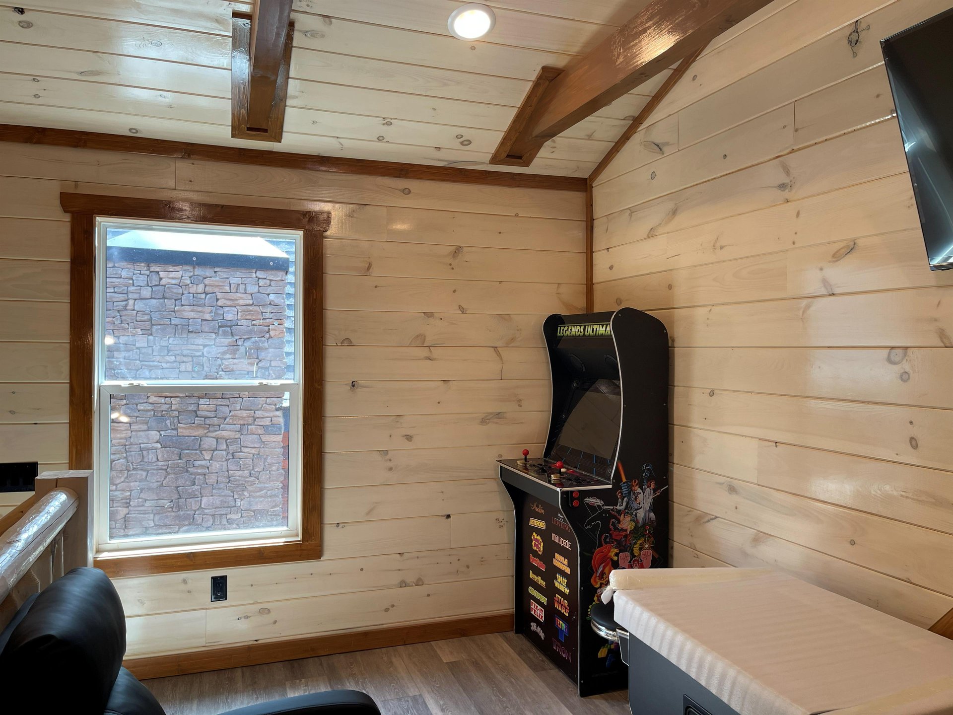 Challenge your friends to classic arcade games in your cozy woodpaneled game room, perfect for hours of nostalgic entertainment.