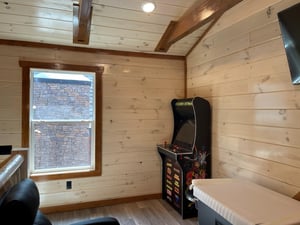 Challenge your friends to classic arcade games in your cozy woodpaneled game room, perfect for hours of nostalgic entertainment.
