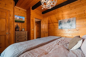 Sink into soft linens in your warm woodpaneled bedroom, with vaulted ceilings and rustic charm wrapping you in cozy comfort.