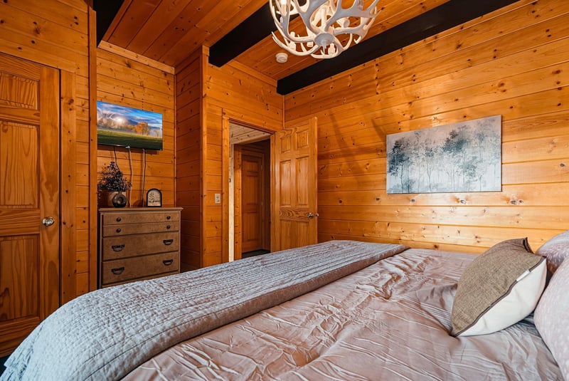 Sink into soft linens in your warm woodpaneled bedroom, with vaulted ceilings and rustic charm wrapping you in cozy comfort.