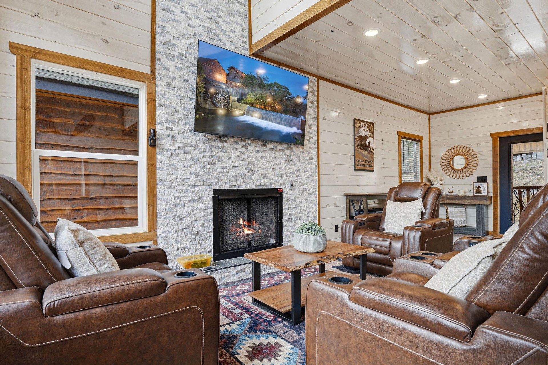 Sink into plush leather recliners by your crackling fireplace, where rustic charm meets modern comfort in this inviting living space.