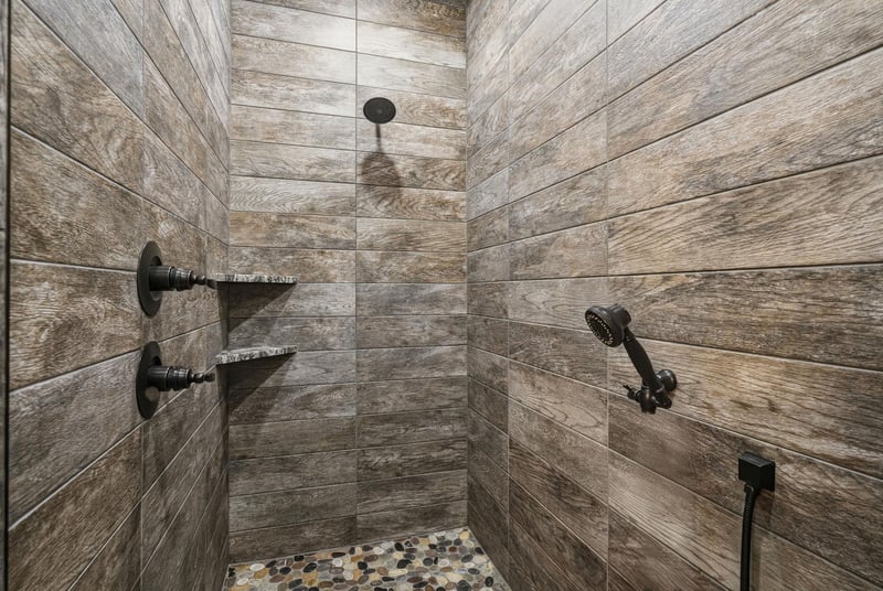 Step into your private spa retreat. Warm woodlook tile wraps around you while dual rainfall fixtures and a handheld spray promise a soothing, rejuvenating escape.