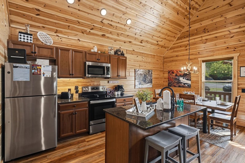 Your mountain retreat features a fullyequipped kitchen with granite counters, stainless appliances, and a cozy island—perfect for gathering over morning coffee or sharing meals surrounded by warm woo