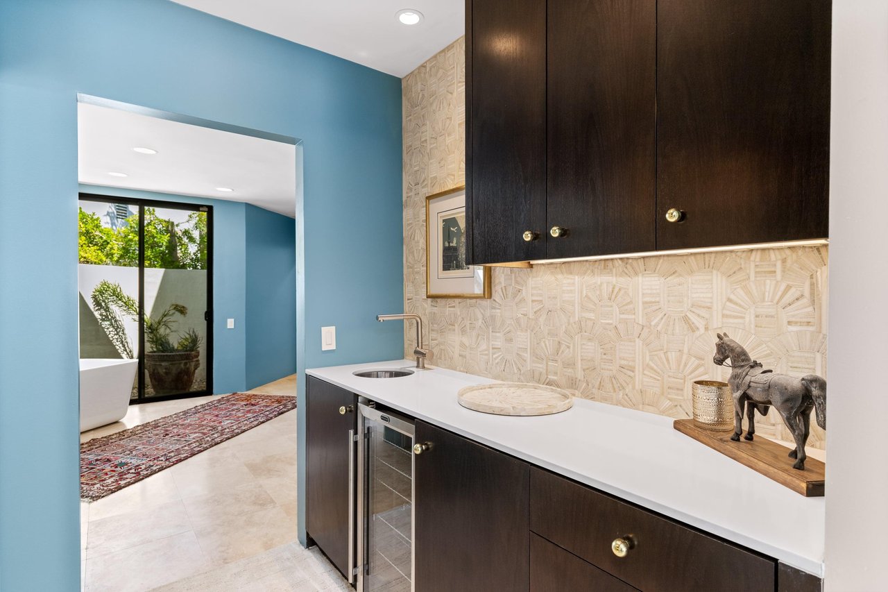 Wet bar with mini fridge leading into the ensuite bathroom.