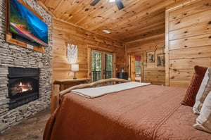 Curl up in your cozy cabin bedroom, where warm wood surrounds you and the fireplace crackles softly beside the bed. Step out to your private balcony and breathe in the peaceful forest air.