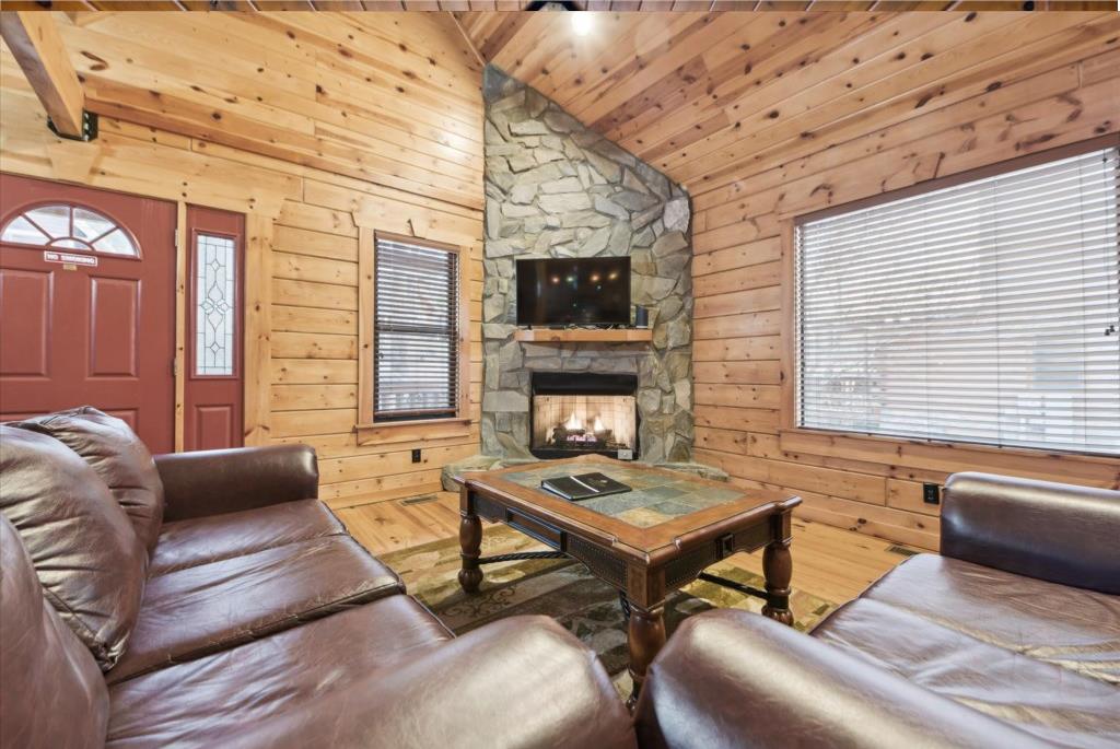 Cozy up in your rustic retreat with leather seating around a crackling fireplace, perfect for evening relaxation.