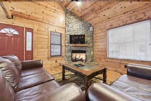 Cozy up in your rustic retreat with leather seating around a crackling fireplace, perfect for evening relaxation.