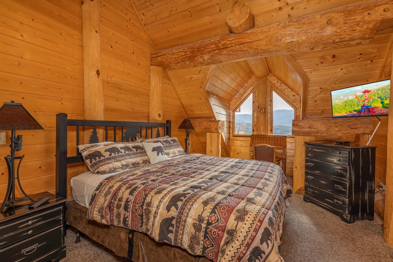 Bedroom with a king bed, night stands, dresser, TV, and views at Grizzlys Den, a 5 bedroom cabin rental located in Gatlinburg