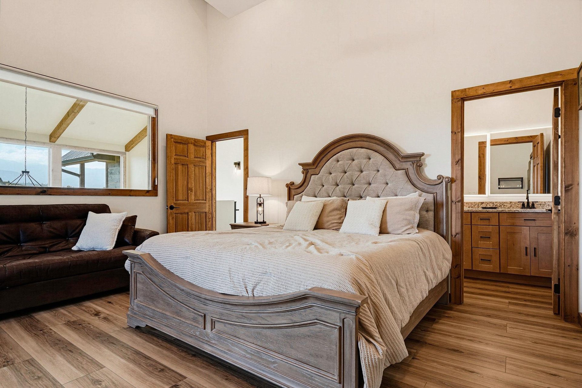 Slip into this inviting bedroom where rustic wood tones meet plush comfort. The upholstered headboard and soft linens create your cozy retreat.