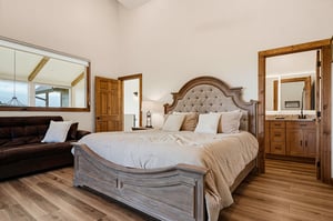 Slip into this inviting bedroom where rustic wood tones meet plush comfort. The upholstered headboard and soft linens create your cozy retreat.