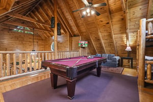 Unwind in your private loft game room, where rustic log beams frame perfect evenings of pool and relaxation.