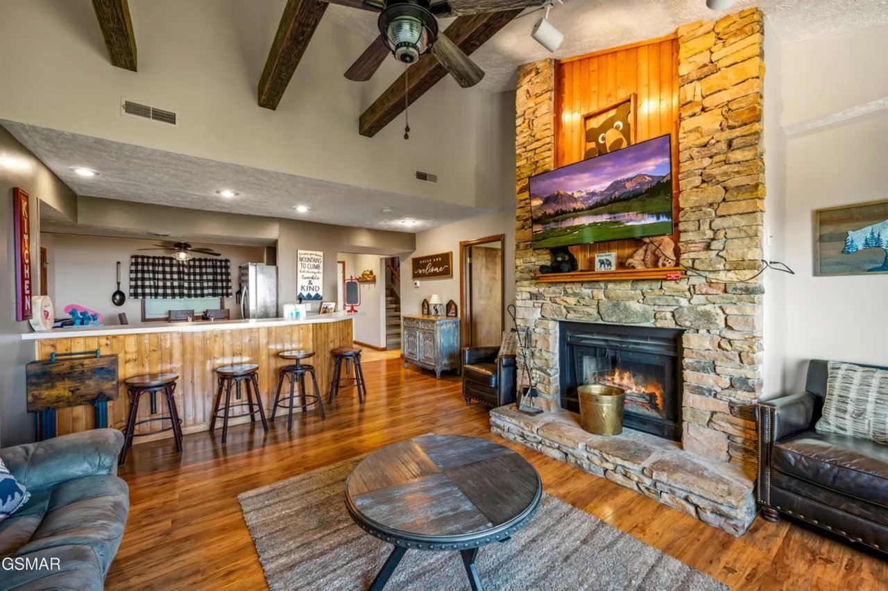 Relax in your rustic yet refined retreat, where exposed beams frame a cozy stone fireplace and open kitchen beckons for memorable meals together.