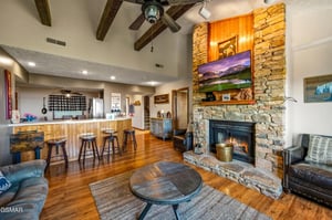 Relax in your rustic yet refined retreat, where exposed beams frame a cozy stone fireplace and open kitchen beckons for memorable meals together.