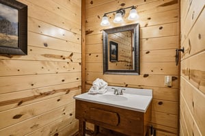 Rustic charm meets comfort in your private bathroom featuring warm wood walls, stylish vanity, and soft lighting for a cozy retreat.