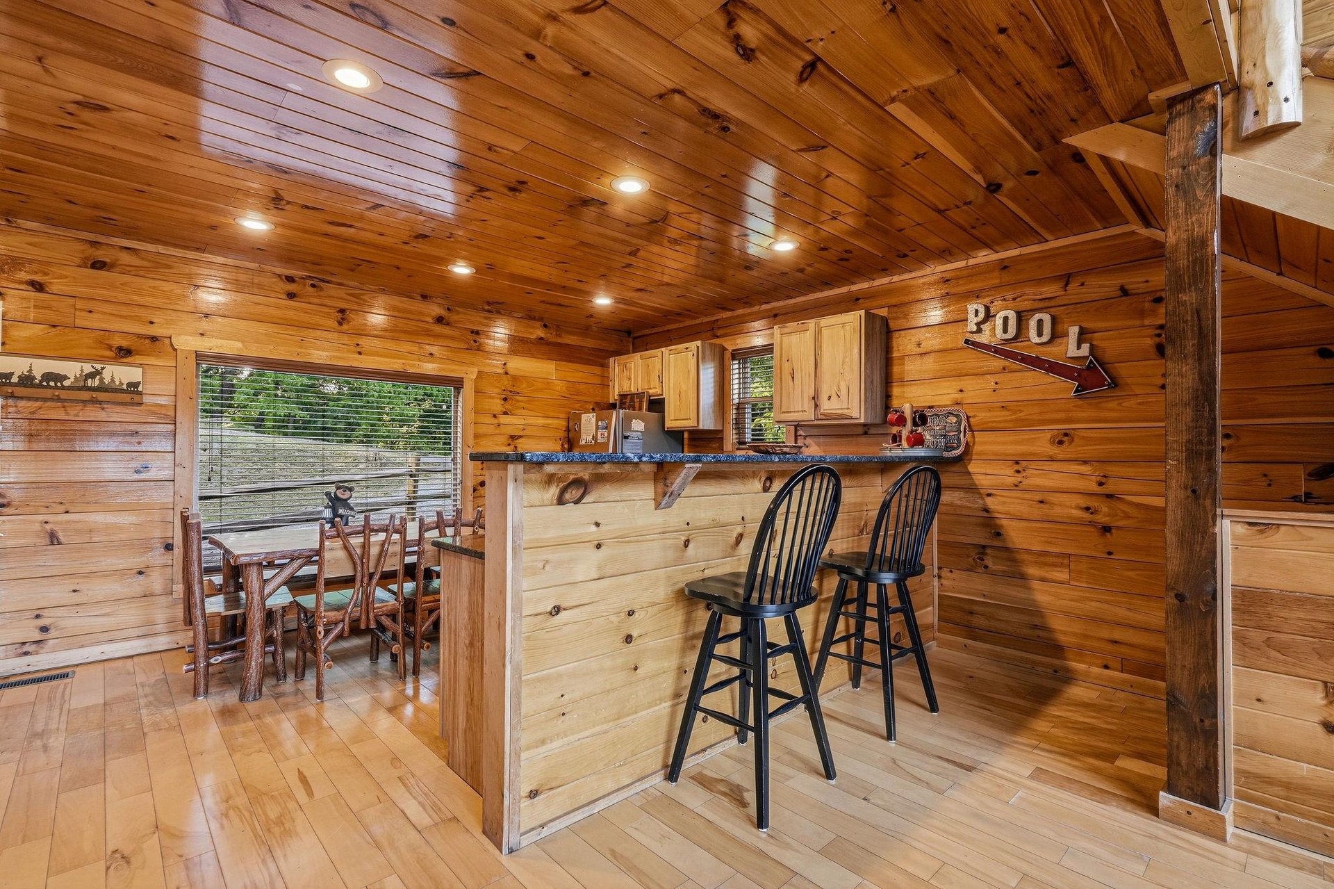 Step into rustic warmth with rich wood walls and ceilings surrounding your private kitchen and bar. Enjoy morning coffee at the counter or gather for meals at the cozy dining nook with a view.