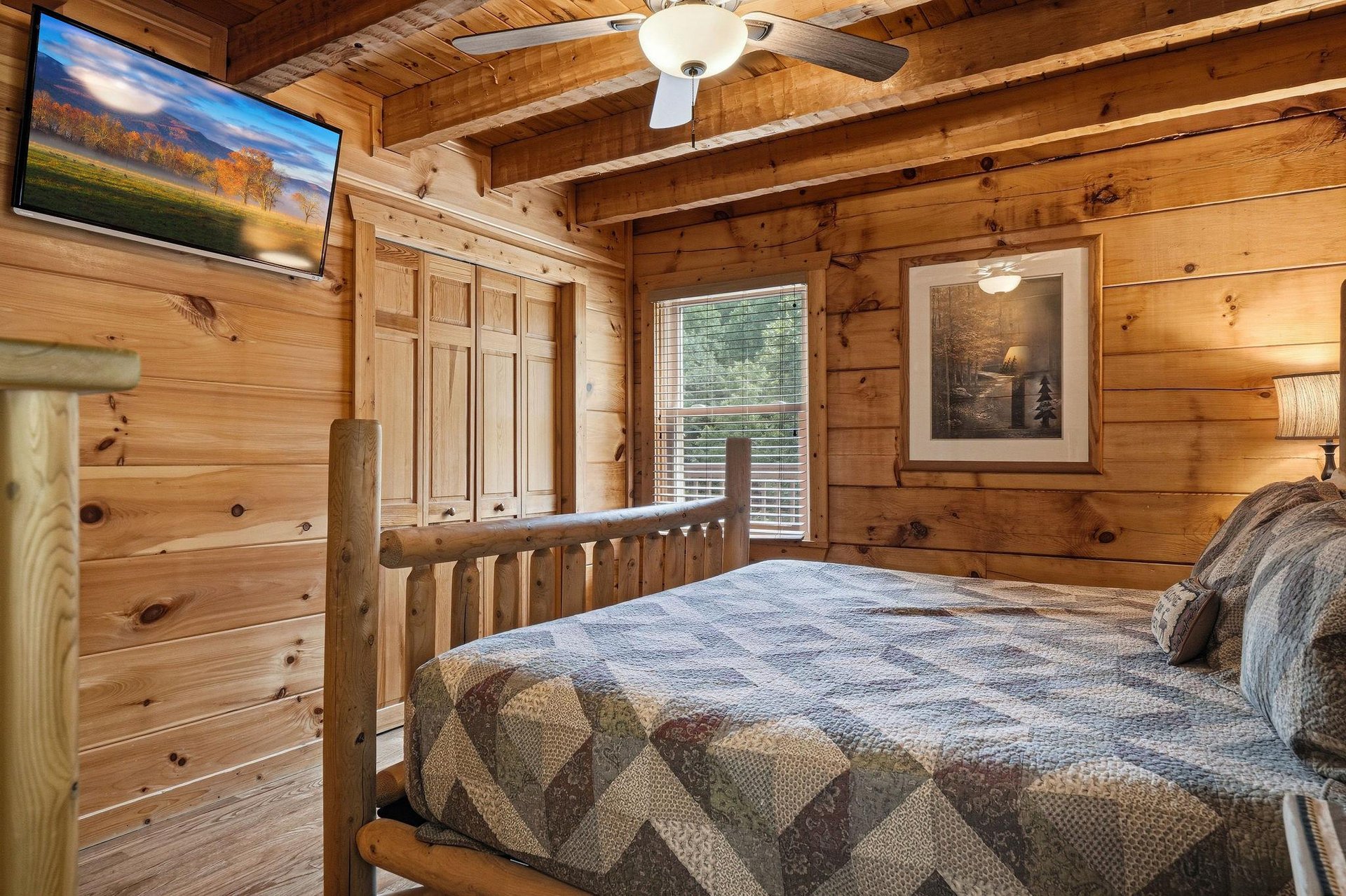 Drift off beneath vaulted pine ceilings and rustic beams in your cozy cabin bedroom, where warm wood surrounds you and gentle light invites deep, restful sleep.