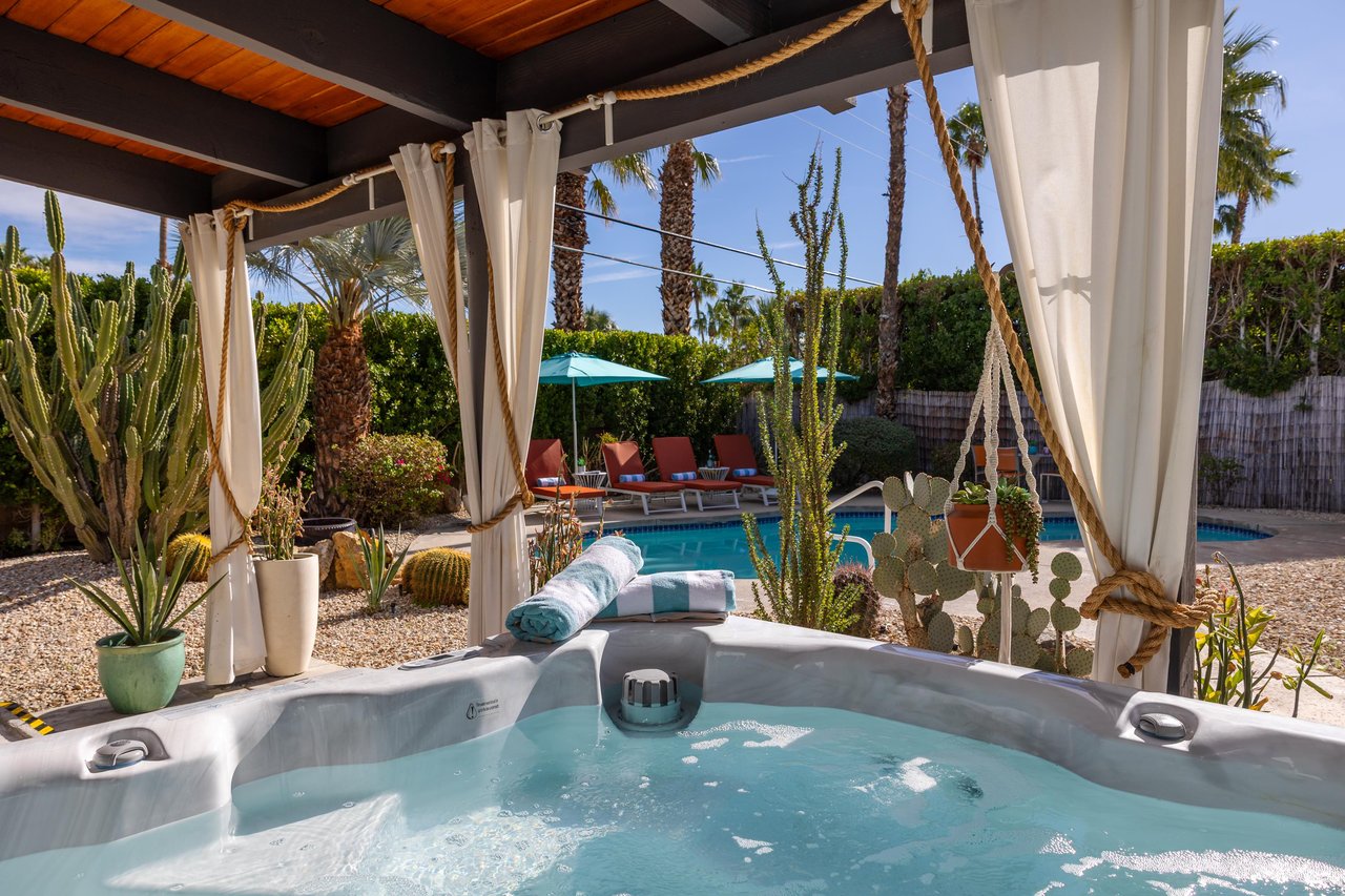 Slip into your private hot tub surrounded by desert palms and cacti, with the sparkling pool just steps away for the perfect oasis retreat.