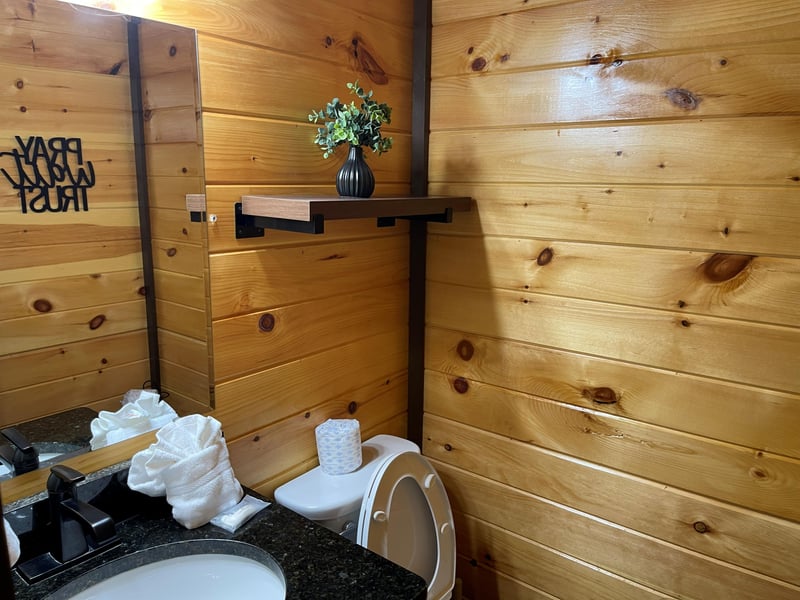 Warm pine walls and thoughtful touches create a cozy, inviting bathroom where you can refresh in comfort.