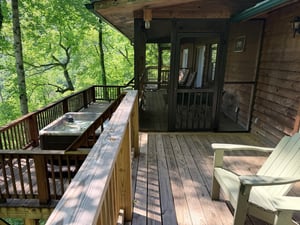 Unwind on your private deck surrounded by lush forest views, where a soothing hot tub and cozy seating invite peaceful mornings and starlit evenings in nature.