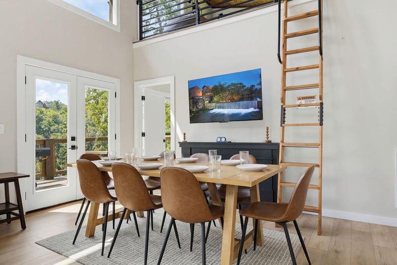 Gather around the spacious dining table in this sunlit, openplan space with soaring ceilings, comfortable seating for eight, and scenic outdoor views through glass doors.