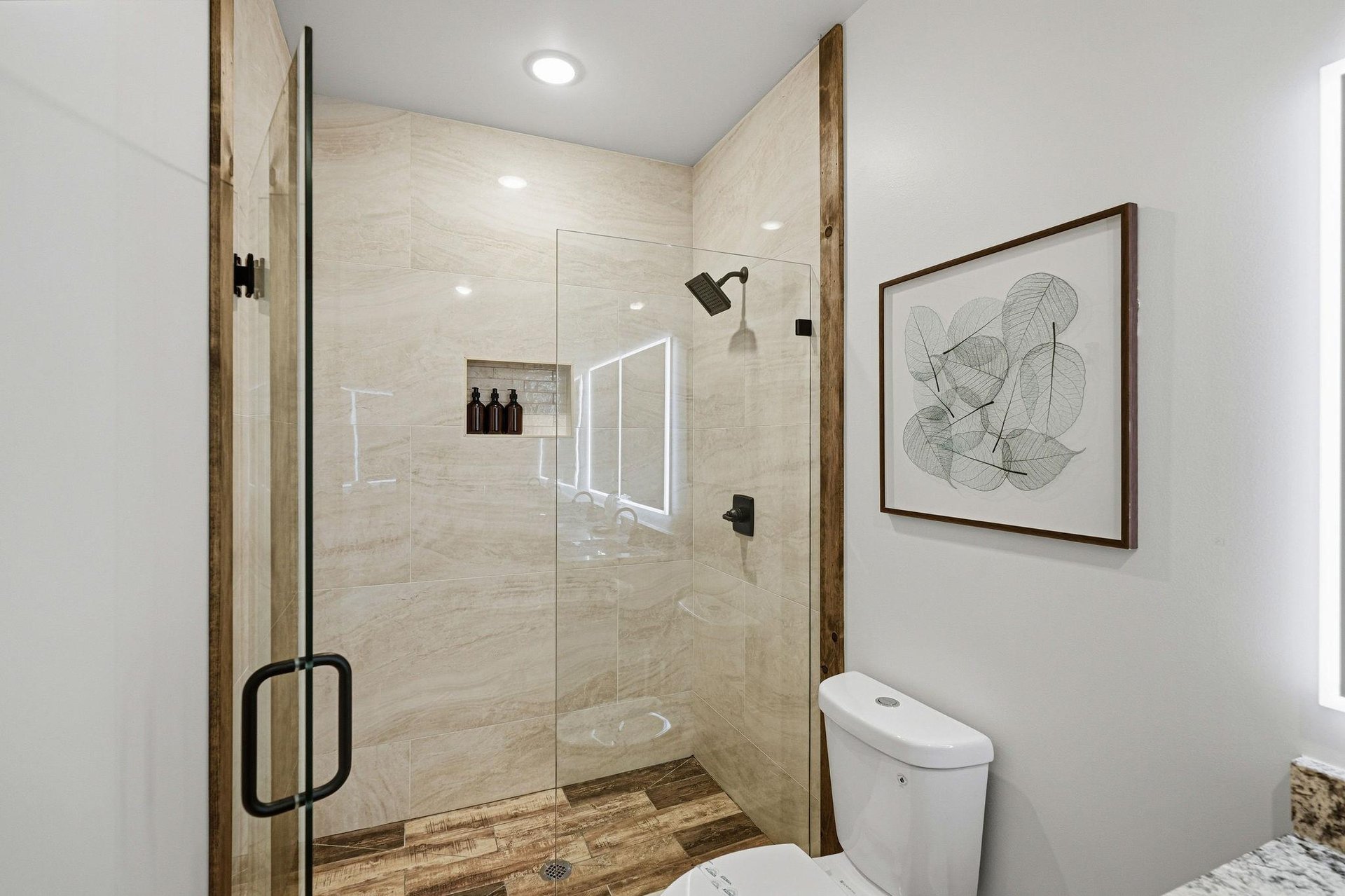 Unwind in your spalike bathroom featuring a spacious glass shower with rainfall head and elegant stone finishes.