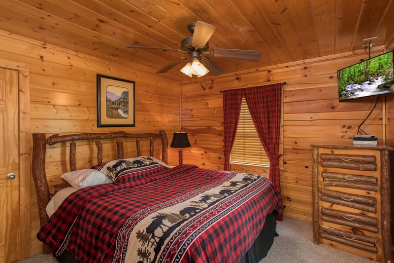 Bedroom with a dresser and TV at Kick Back  Relax A 4 bedroom cabin rental located in Pigeon Forge