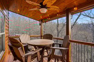 Enjoy peaceful forest views from this covered deck with comfortable seating for your morning coffee or evening relaxation.