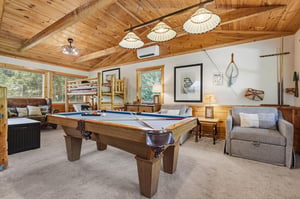 Your ultimate game room awaits with vaulted wood ceilings, cozy seating, and a billiard table ready for friendly competition. Relax between rounds on the plush sofas or challenge the family to a tourn