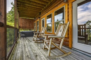 Picture yourself rocking gently on this peaceful balcony, breathing in fresh mountain air and soaking up tranquil forest views—your perfect retreat for morning coffee or evening relaxation.