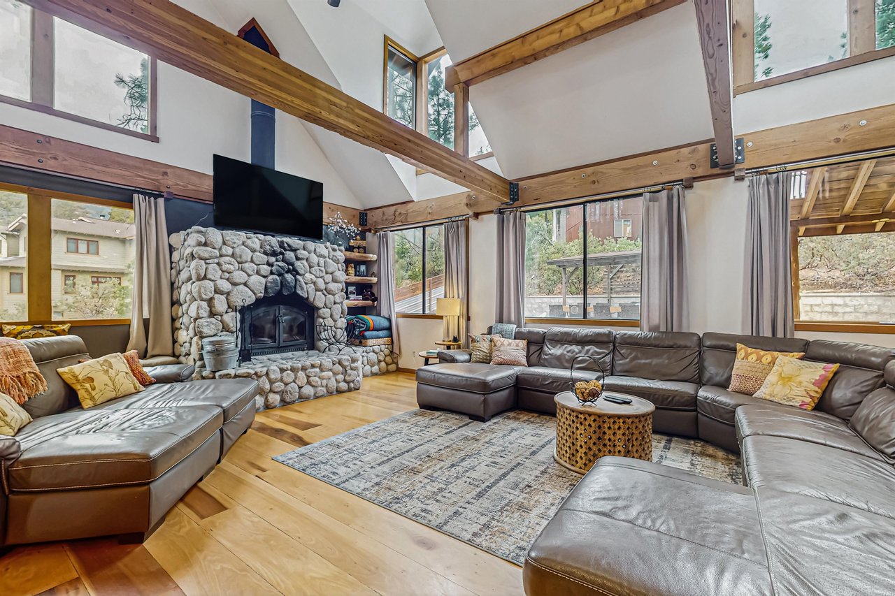 Another view of the great room, showing the dramatic stone fireplace and smart TV with DVD player and cable — perfect for cozy movie nights in Idyllwild.