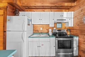 Kitchen with white cabinets and appliances at Living on Love, a 2 bedroom cabin rental located in Pigeon Forge