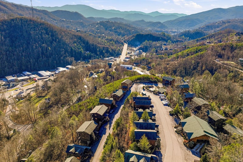 Aerial view of mountain resort community nestled in scenic Smoky Mountain foothills with winding roads and forested valleys.