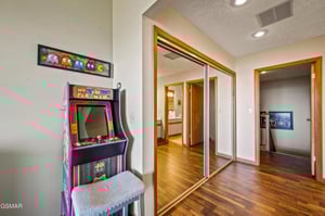 Challenge friends to arcade games in this fun space with retro gaming and sleek mirrored closets for all your belongings.