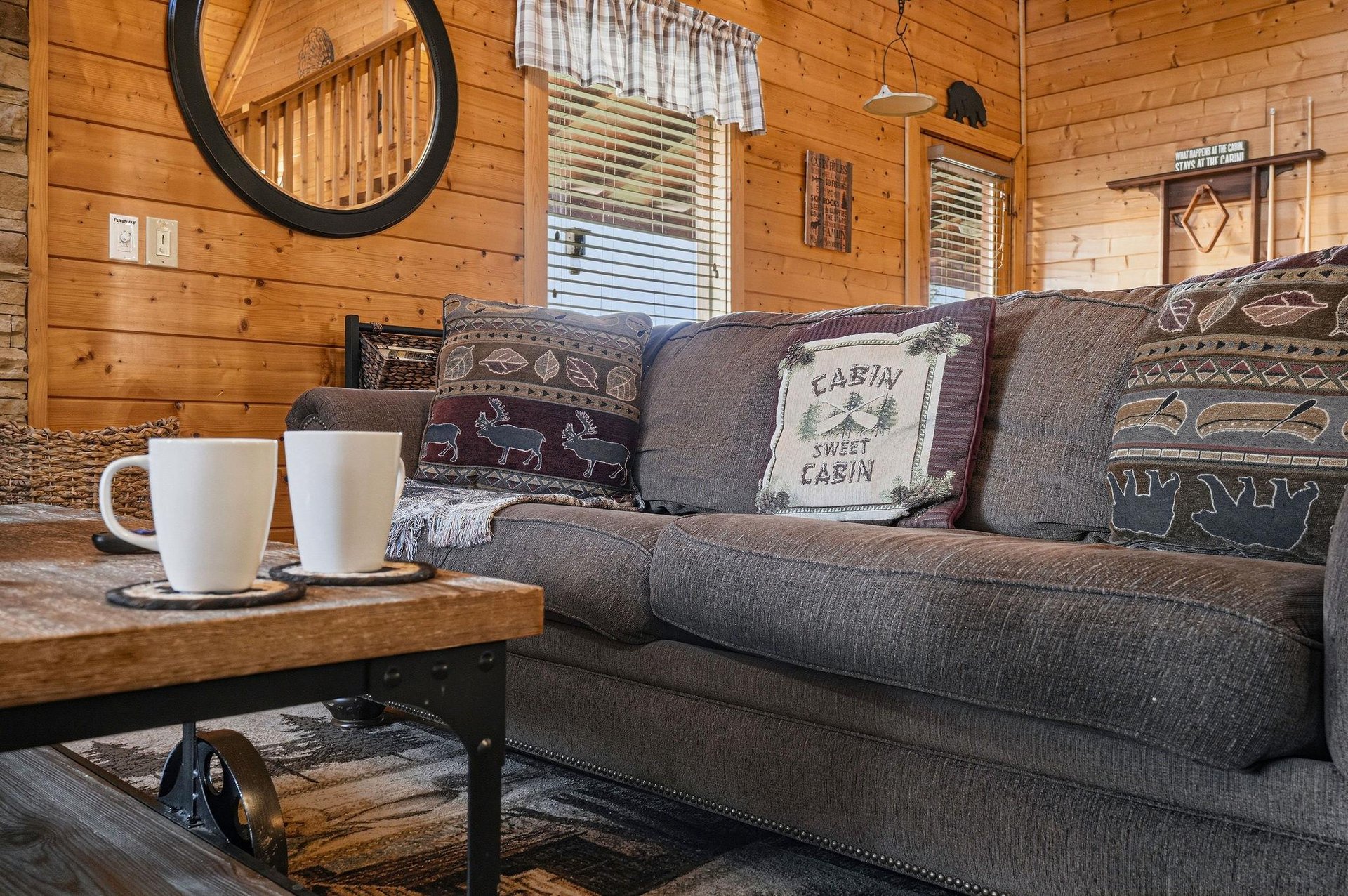 Sink into this cozy sofa with your morning coffee and soak in the warm cabin vibes. Natural light streams through, while charming touches and rustic wood surround you in mountaininspired comfort.